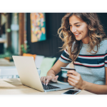 A woman holds her credit card while she looks at her laptop