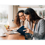 Two colleagues sit at a desk and work together