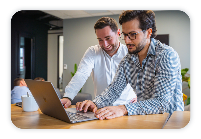 Two colleagues look at a laptop